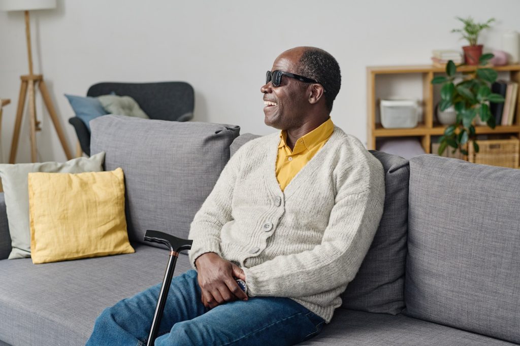 African blind man sitting at home