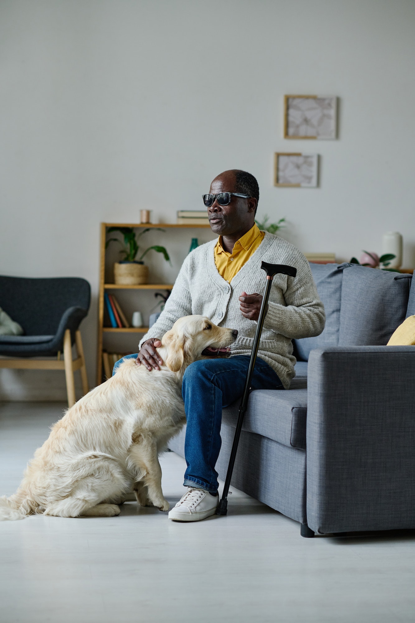 Blind senior man with guide dog at home