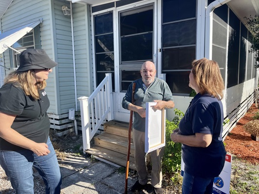 Before starting the ramp project, Anna Terry (Executive Director of Space Coast Habitat) and Rose Miles (Executive Director of RCDS) speaking with veteran. 